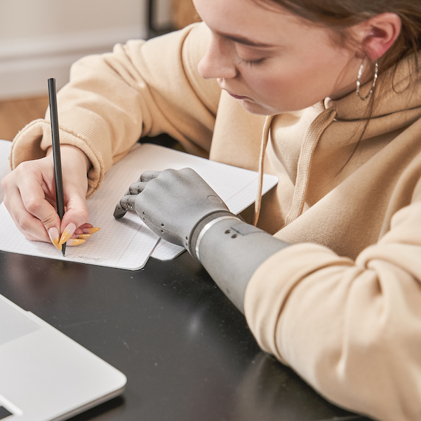 A student veteran wears a prosthetic hand while she studies