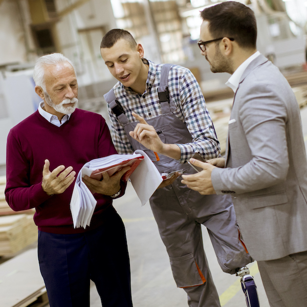 Three workers discuss a project