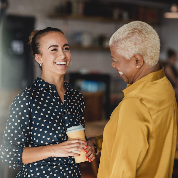 An student veteran is smiling while chatting with a colleague at her internship