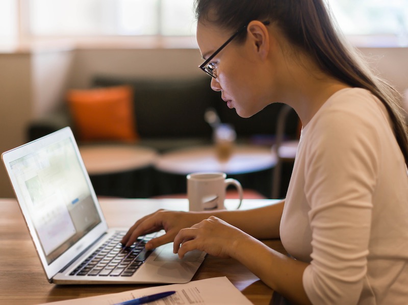 A student veteran concentrates while using her laptop to find the information she needs on the Web